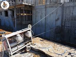 قص الخرسانة باستخدام السلك الماسي في موقع بناء لقطع الكتل الخرسانية المسلحة بدقة عالية مع استخدام نظام بكرات ورش الماء لتقليل الغبار والاهتزازات